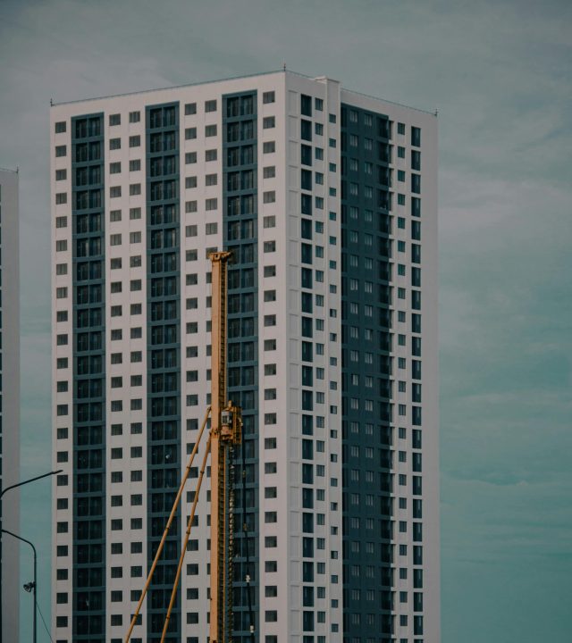 High-rise buildings in Malé with construction crane against a cloudy skyline. Modern urban architecture.